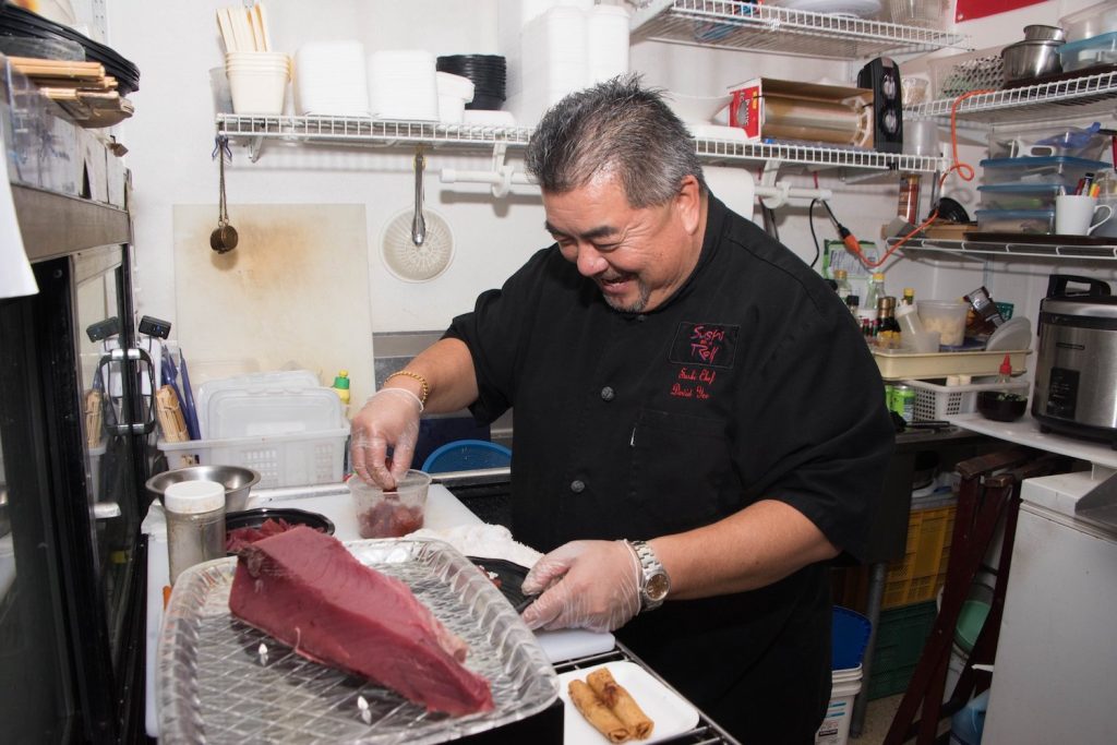 Chef at Kyoto Gift & Food an Asian restaurant and market in National City, San Diego cooking a piece of bluefin tuna